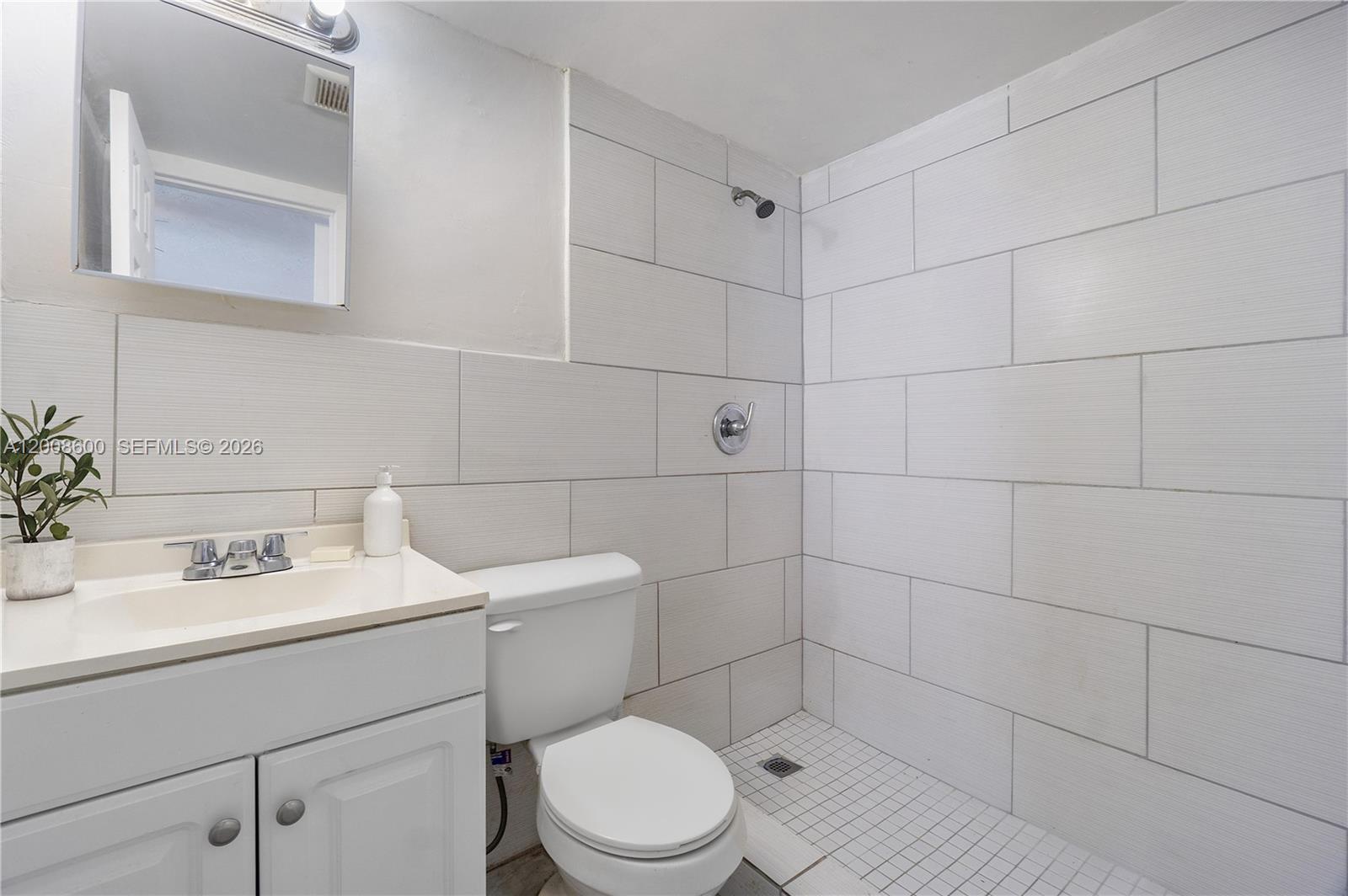 332 Southwest 3rd Street, Unit 2 Belle Glade, FL 33430 - Photo 6 of 7 a bathroom with a sink toilet and shower