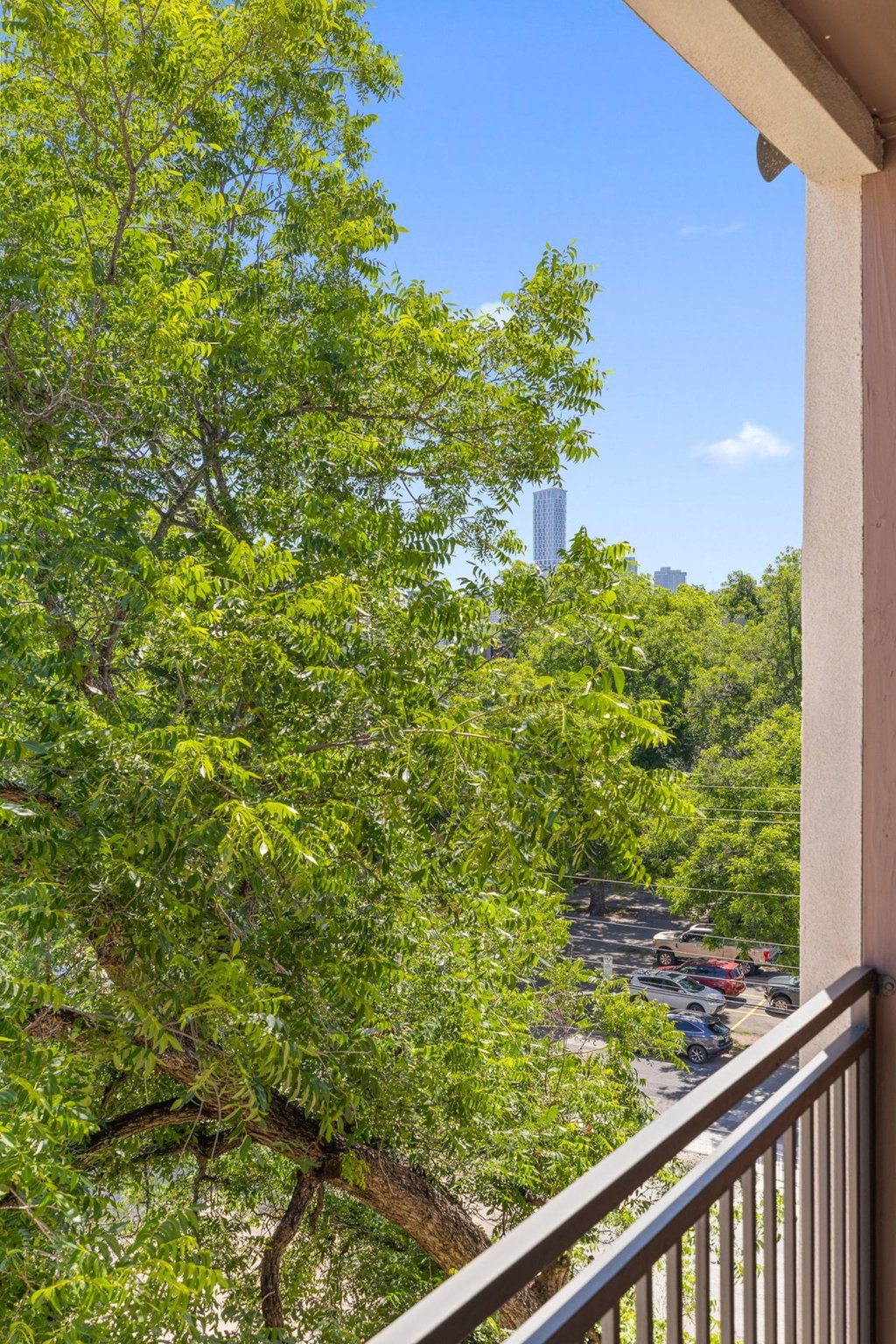 1900 Barton Springs Road, Unit 5009 Austin, TX 78704 - Photo 15 of 35 A tranquil balcony provides verdant tree canopy views, with urban skyline glimpses beyond.