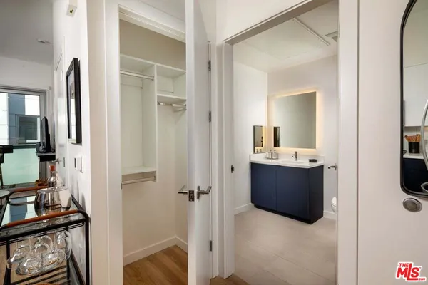 a view of walk in closet with clothes and shoes