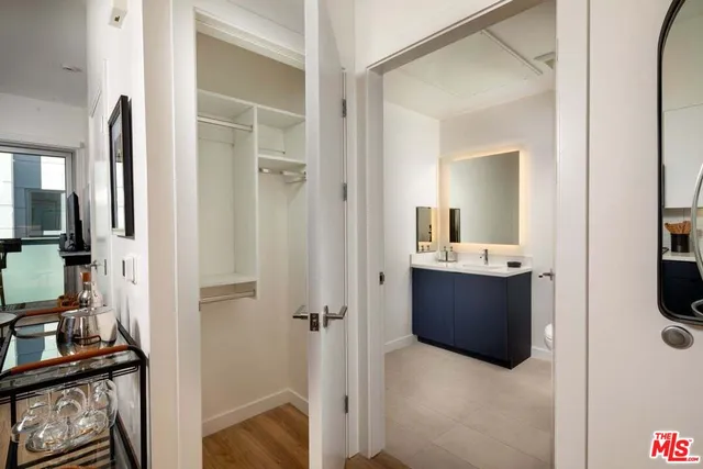 a view of walk in closet with clothes and shoes