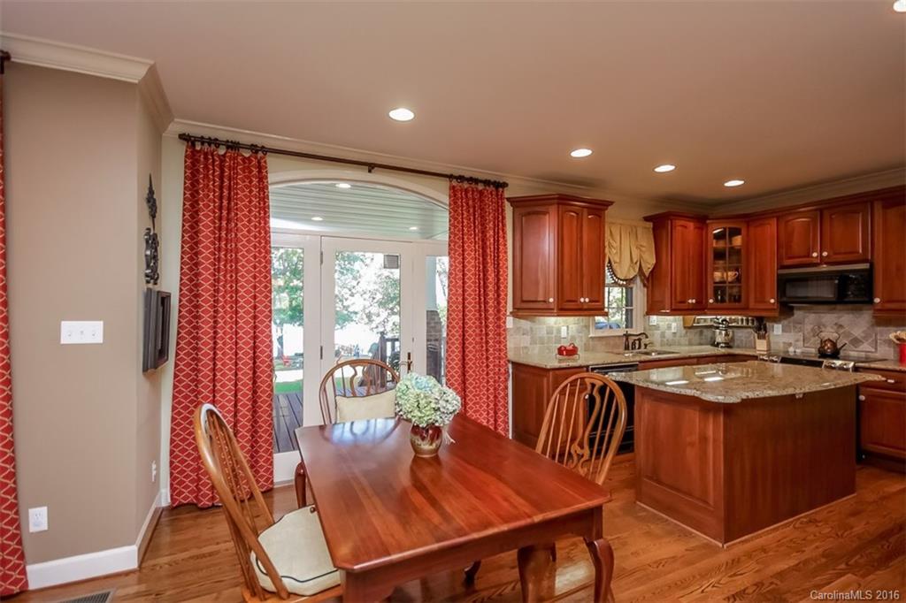 4567 Kiser Island Road Terrell, NC 28682 - Photo 9 of 24 a kitchen with stainless steel appliances granite countertop a stove top oven a sink dishwasher a dining table and chairs with wooden floor