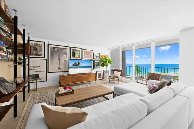 a living room with furniture kitchen view and a large window