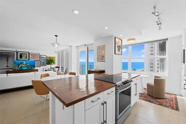 a large kitchen with kitchen island a white cabinets and stainless steel appliances