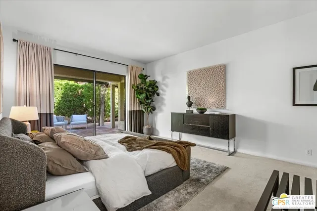 a bedroom with a bed a mirror and a lamp on table