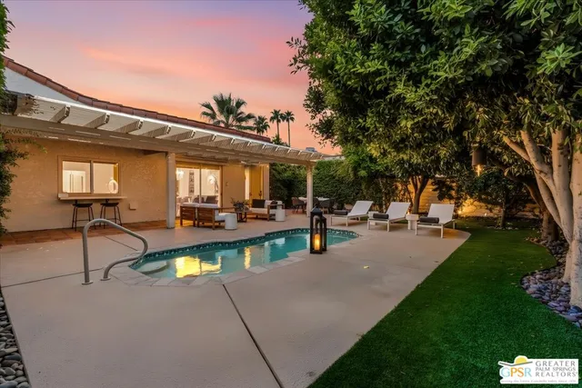 a view of a patio with table and chairs potted plants and palm trees