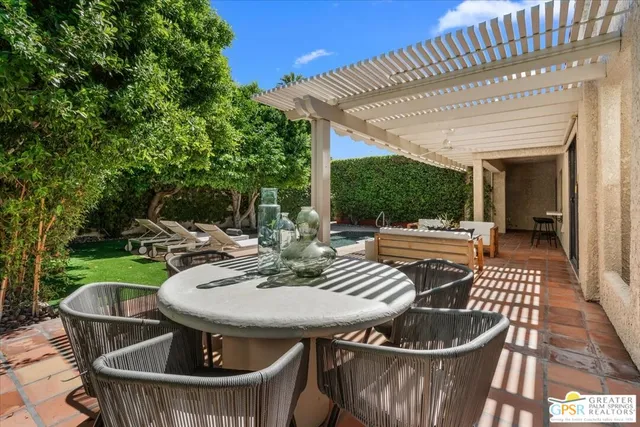 a view of a patio with a table and chairs under an umbrella