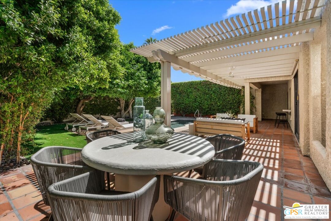 55 Sierra Madre Street Rancho Mirage, CA 92270 - Photo 38 of 59 a view of a patio with table and chairs potted plants with wooden floor and fence