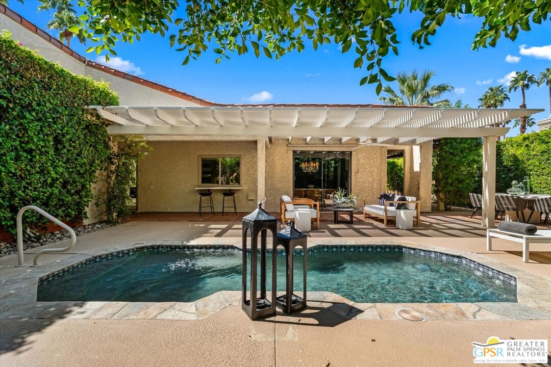 55 Sierra Madre Street Rancho Mirage, CA 92270 - Photo 41 of 59 a view of a patio with table and chairs potted plants and palm trees