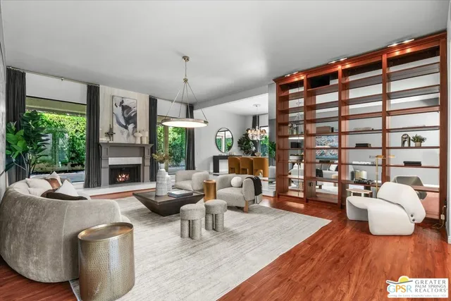 a living room with furniture a chandelier and a wooden floor