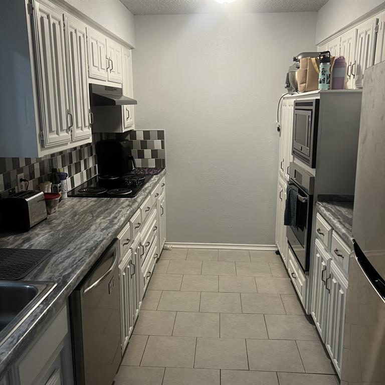 2029 Springwood Place, Unit A Carrollton, TX 75006 - Photo 5 of 9 a kitchen with stainless steel appliances granite countertop a stove a sink and a refrigerator