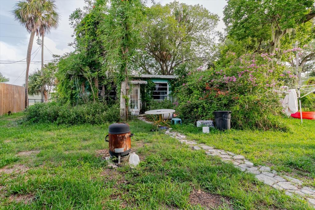 5323 Circle Drive Weeki Wachee, FL 34607 - Photo 56 of 77 a backyard of a house with table and chairs potted plants and large tree