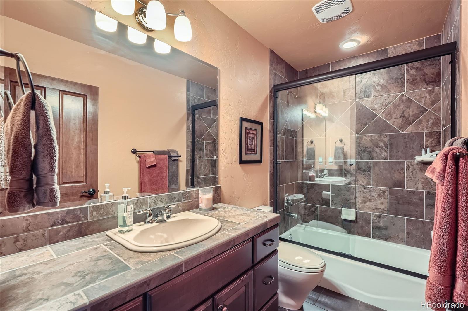 401 Raptor Point Golden, CO 80403 - Photo 19 of 40 a bathroom with a sink a toilet a mirror and shower