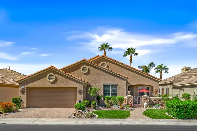 a front view of a house with a yard and potted plants