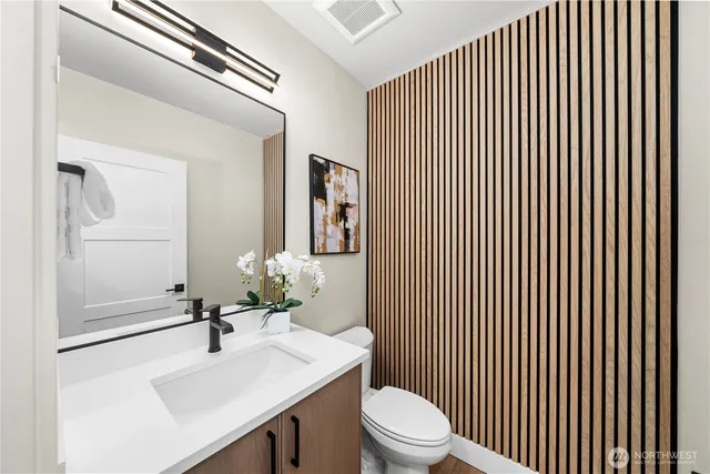 a bathroom with a sink a toilet and mirror