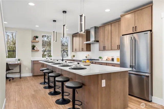 a kitchen with stainless steel appliances granite countertop a sink refrigerator and cabinets