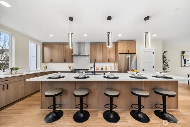 a kitchen with cabinets a sink dishwasher a stove and chairs with wooden floor