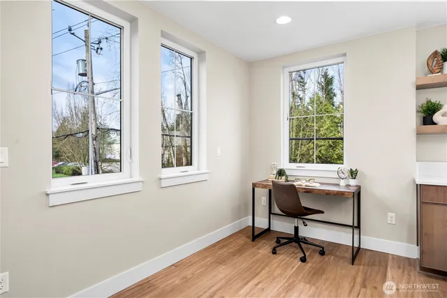 a view of a workspace with furniture and a window