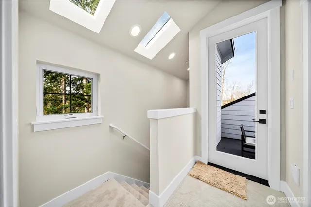 a view of a hallway to rooms and stairs