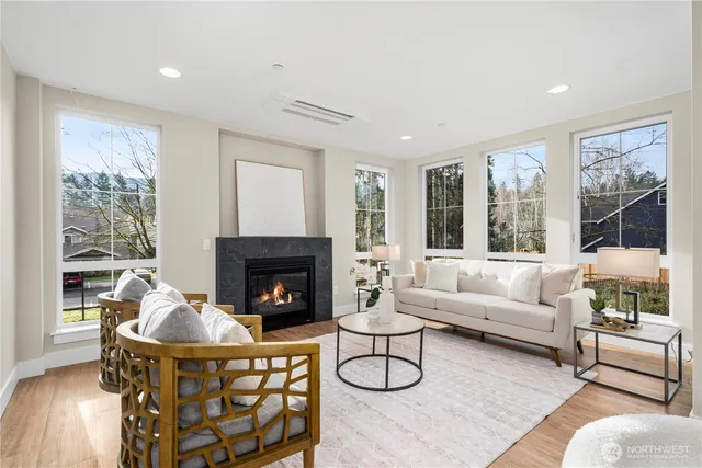 a living room with furniture a fireplace and a large window