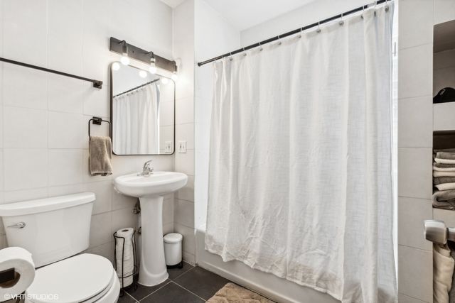 a bathroom with a sink a toilet and shower curtain