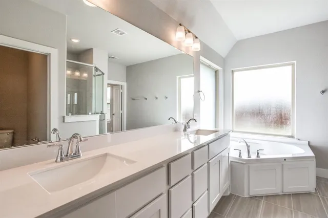 a bathroom with a tub sink and mirror