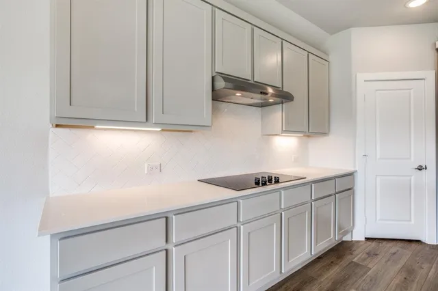 a kitchen with stainless steel appliances granite countertop white cabinets and a sink