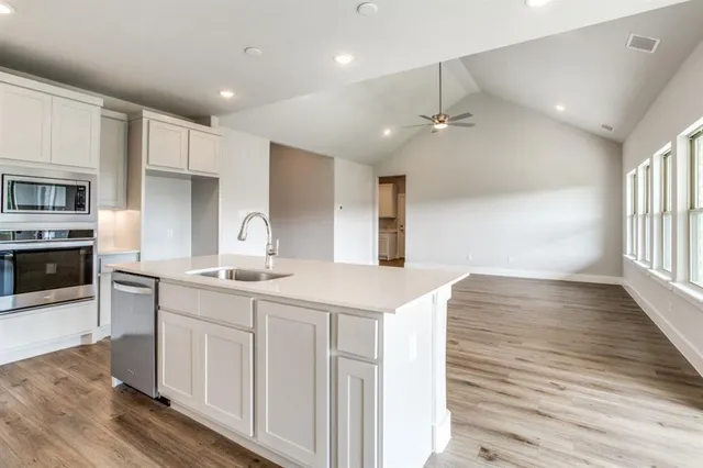 a kitchen with granite countertop a sink stove and refrigerator