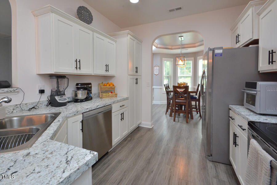 195 Timberwind Road Franklinton, NC 27525 - Photo 13 of 28 a kitchen with granite countertop a sink stove and refrigerator