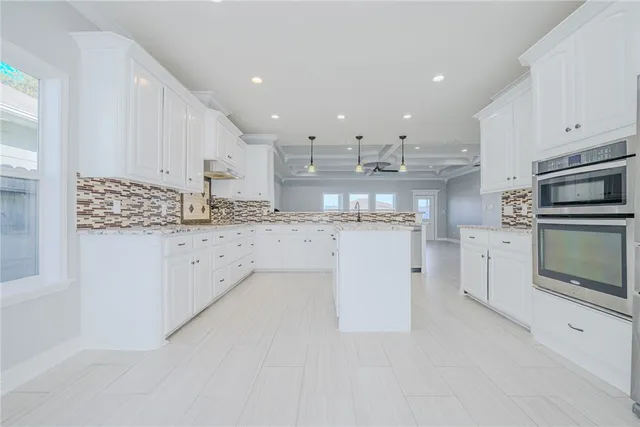 a kitchen with stainless steel appliances granite countertop a refrigerator and a stove top oven