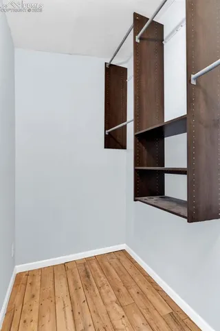 a view of a room with wooden floor and a window