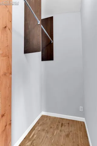 a view of an empty room with wooden floor