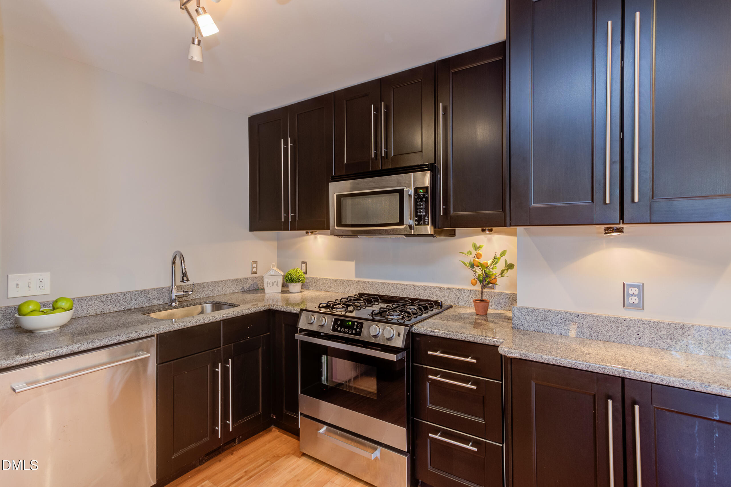 2556 Noble Road Raleigh, NC 27608 - Photo 10 of 29 a kitchen with granite countertop stainless steel appliances and wooden cabinets