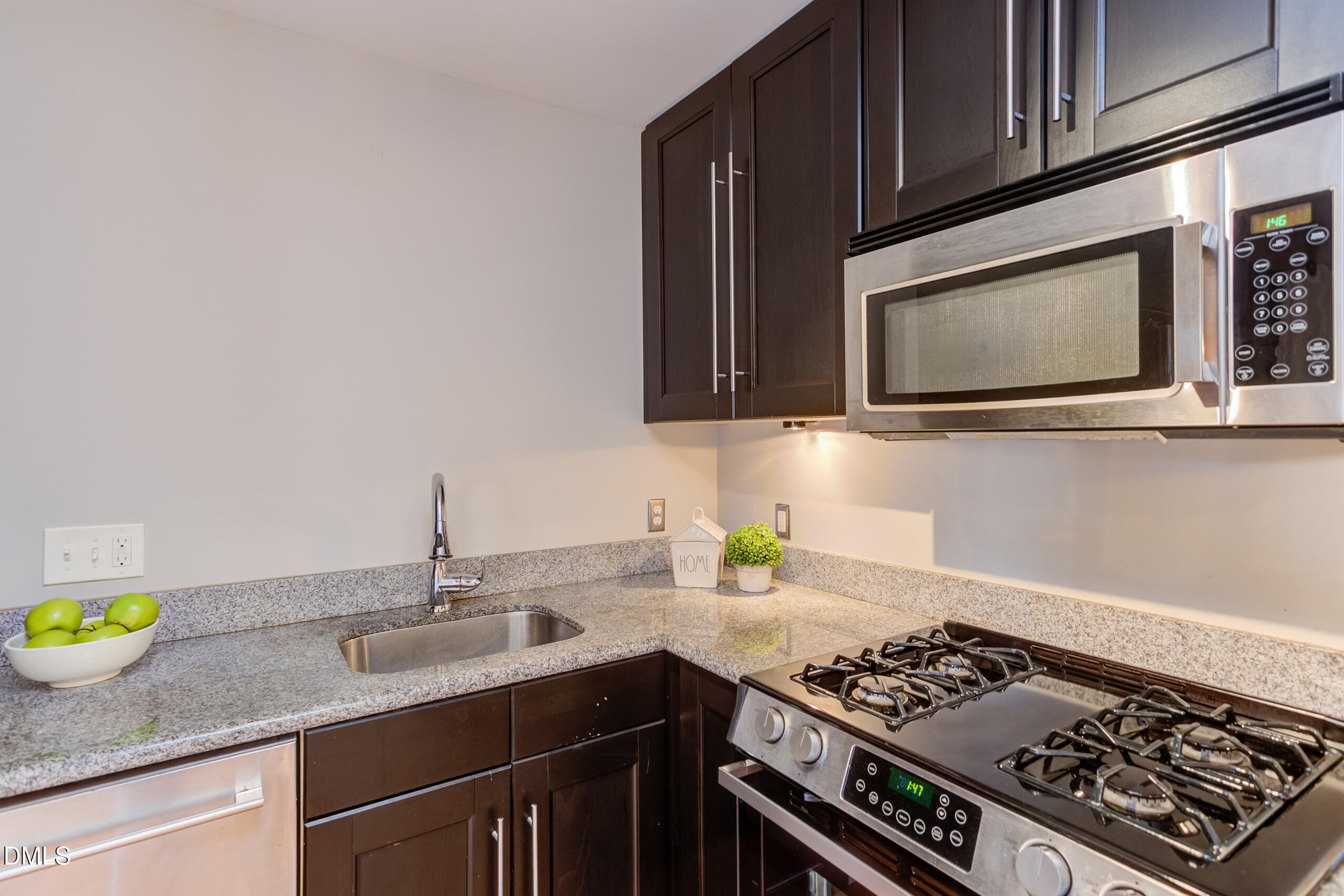 2556 Noble Road Raleigh, NC 27608 - Photo 11 of 29 a kitchen with stainless steel appliances granite countertop a sink stove and microwave
