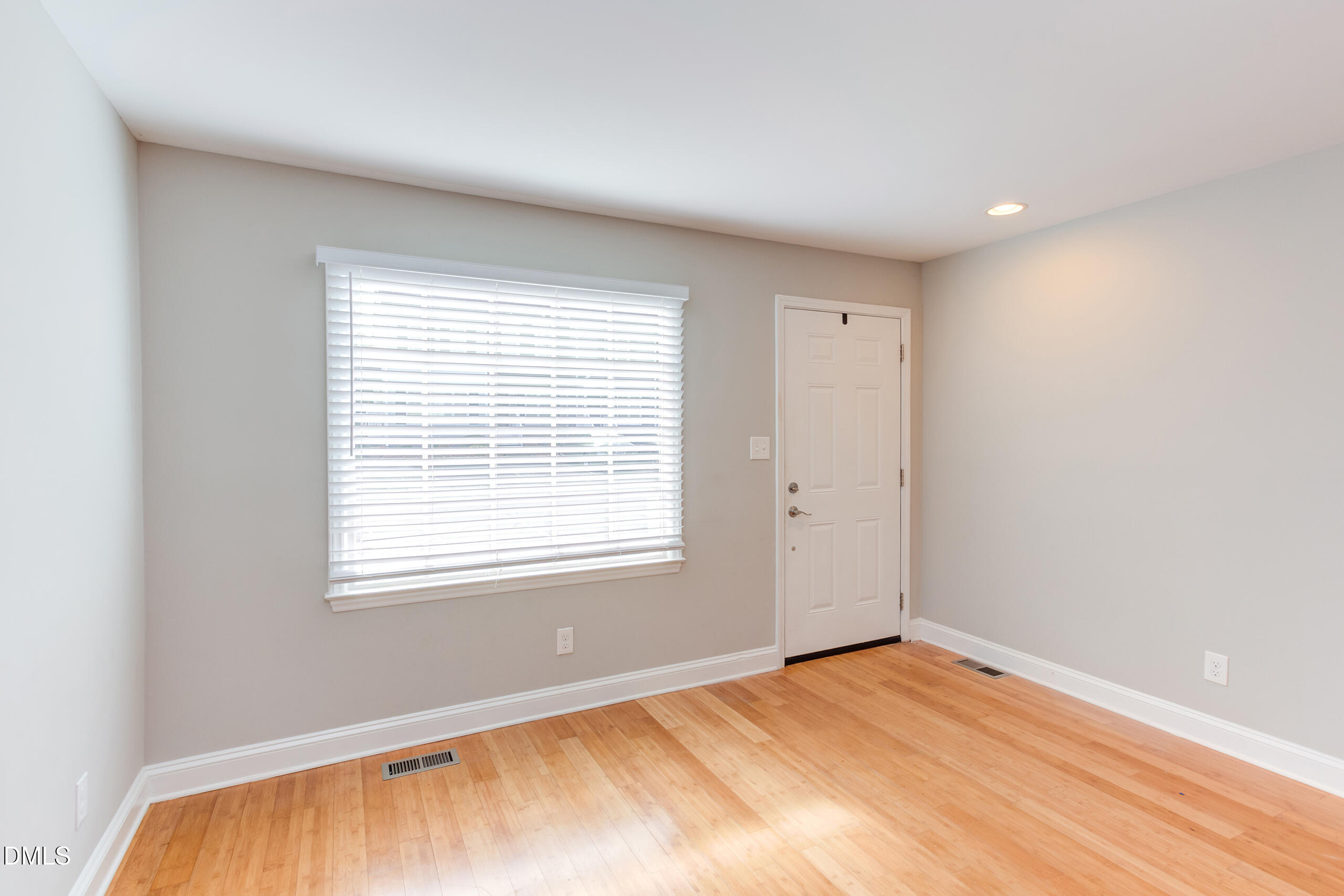 2556 Noble Road Raleigh, NC 27608 - Photo 5 of 29 a view of an empty room with wooden floor and a window