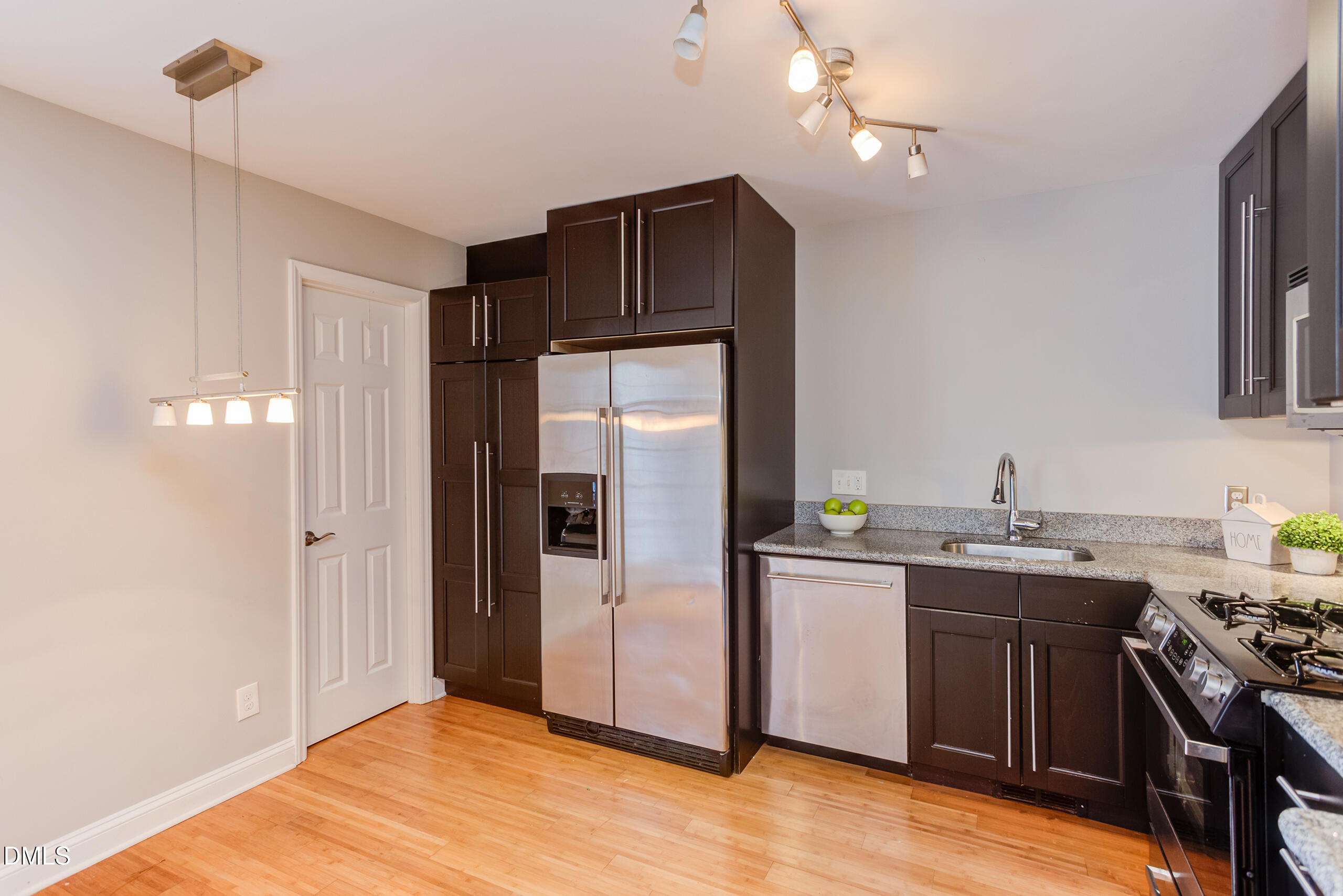 2556 Noble Road Raleigh, NC 27608 - Photo 8 of 29 a kitchen with stainless steel appliances granite countertop a sink a stove a refrigerator cabinets and wooden floor