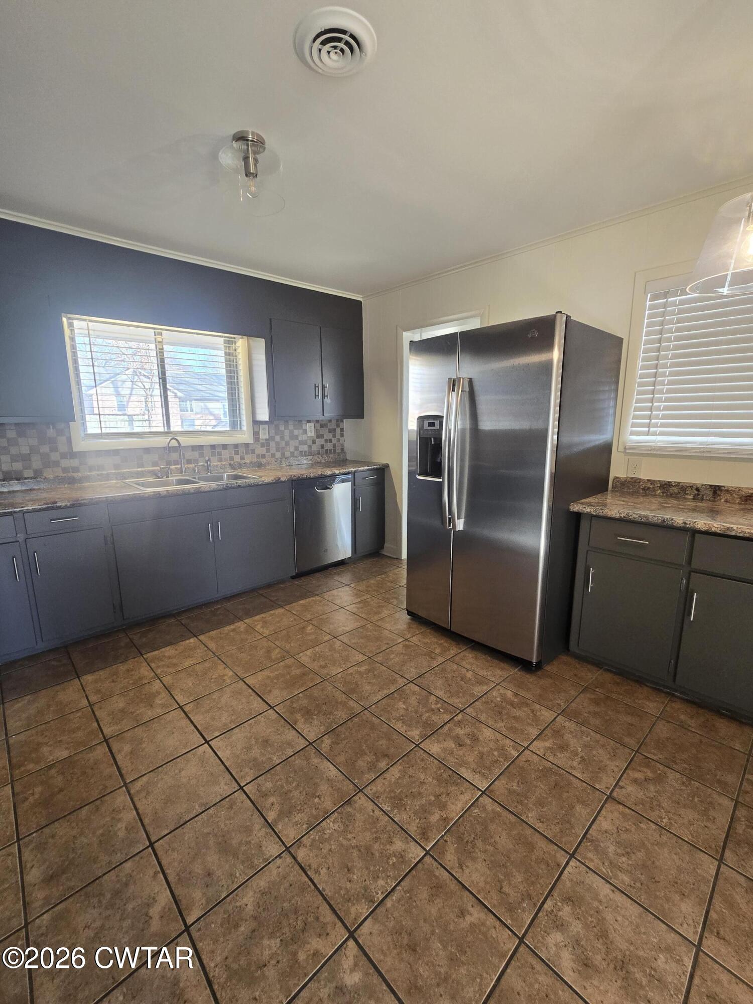 69 Lilac Lane Jackson, TN 38301 - Photo 11 of 23 a kitchen with granite countertop a refrigerator and a stove top oven