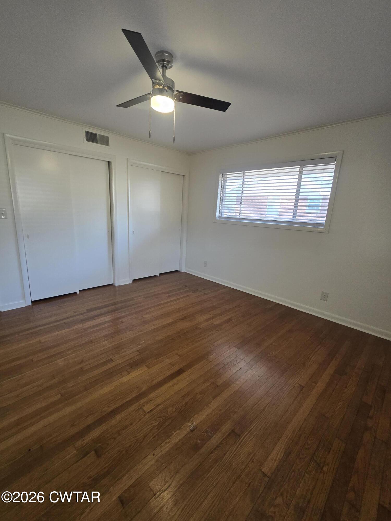 69 Lilac Lane Jackson, TN 38301 - Photo 16 of 23 an empty room with wooden floor fan and windows