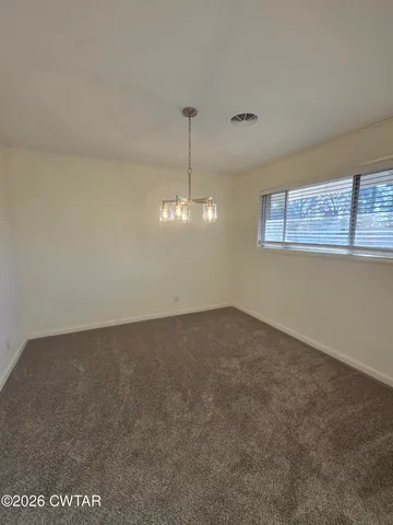a view of a room with a chandelier fan