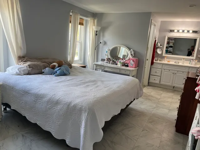 a spacious bedroom with a bed and a flat screen tv