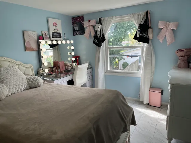 a bedroom with a bed and large windows