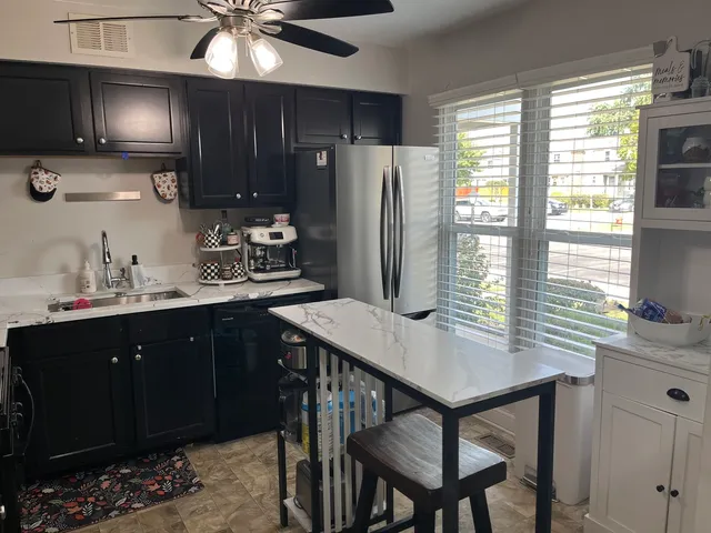 a kitchen with a table chairs refrigerator and microwave