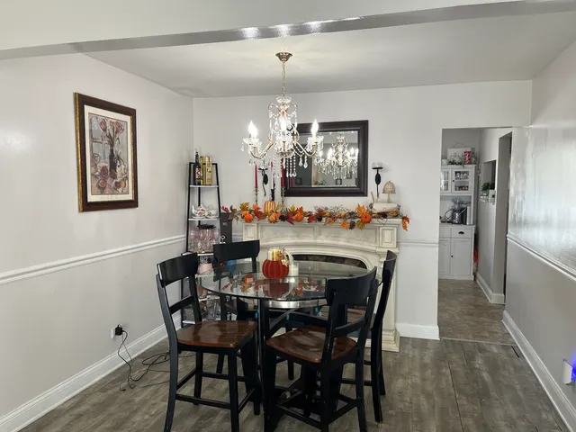 a dining room with furniture a chandelier and wooden floor