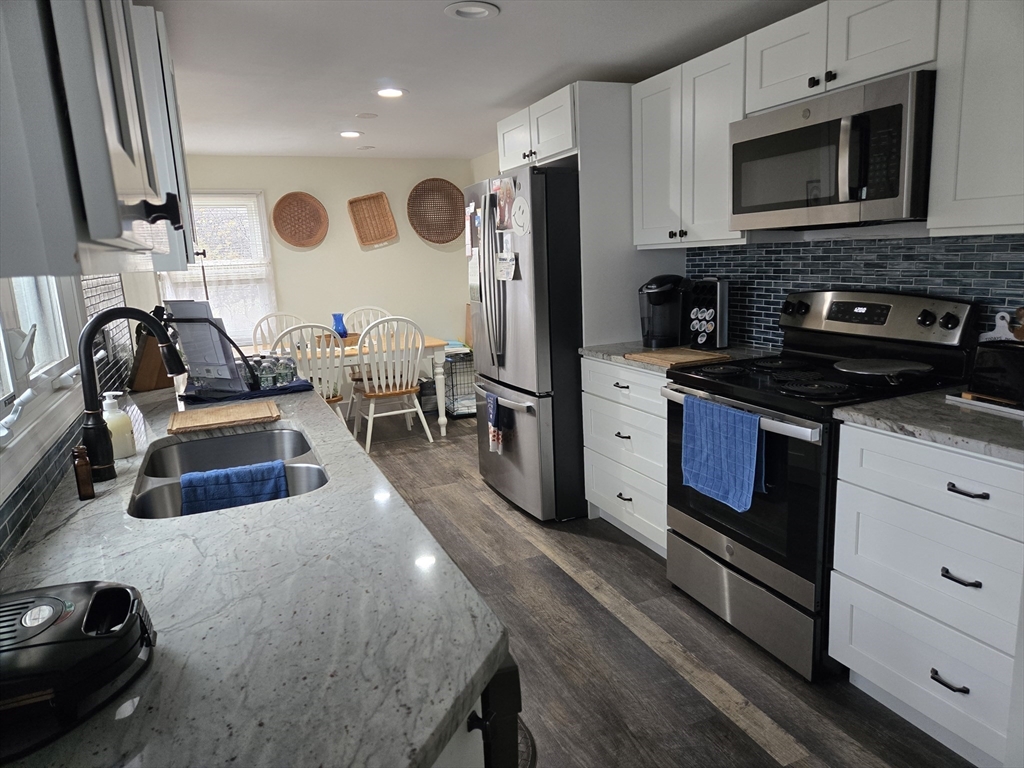 18 Fairview Avenue Dudley, MA 01571 - Photo 6 of 19 a kitchen with stainless steel appliances granite countertop a stove a sink and a microwave