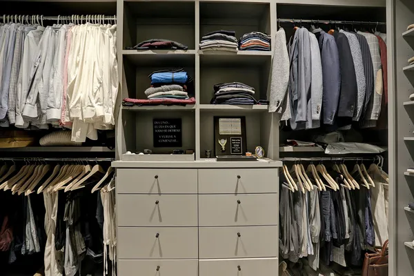 a walk in closet with a large window and furniture