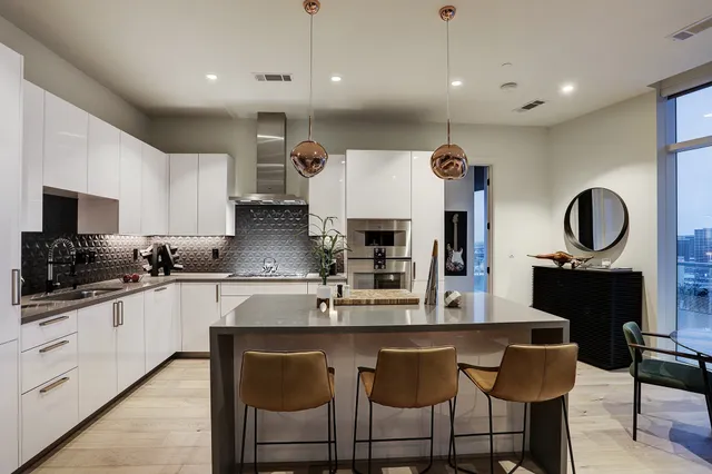 a kitchen with granite countertop a sink cabinets and stainless steel appliances