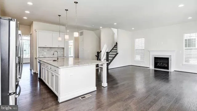 a kitchen with kitchen island a sink and a wooden floor