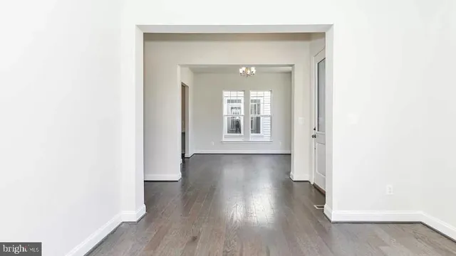 a view of a hallway with wooden floor and a window