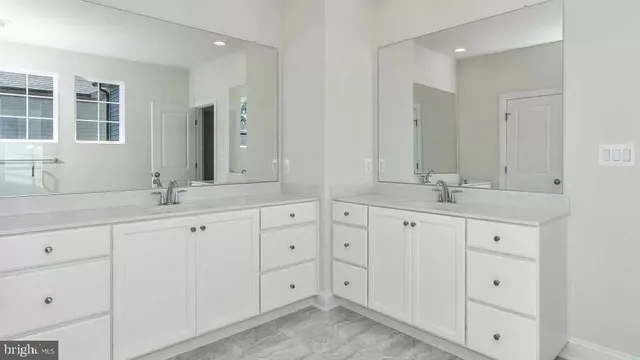 a spacious bathroom with double sink and a mirror