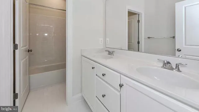 a bathroom with a granite countertop sink a mirror and a bathtub