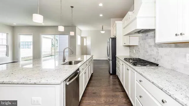 a large kitchen with granite countertop a sink and a stove